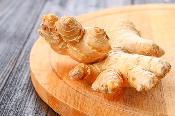 Spicy root of ginger on a wooden table.