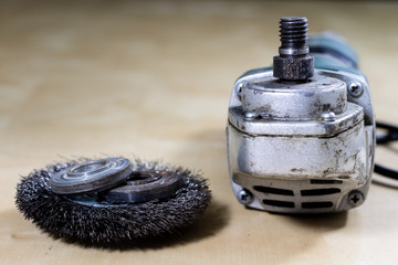 Obraz premium Angle grinder and safety glasses on a workshop wooden table. Metalwork accessories for metalworking.