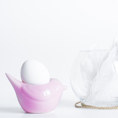 White Easter Egg in pink egg stand with decoration