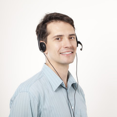 Young man talking by headphones and smiling