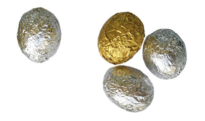 One golden and three silver eggs on a white background.Eggs covered with crumpled foil