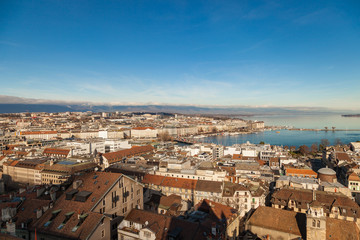 Fototapeta premium Geneva old city roofs and lake. Geneva aerial view from St. Pierre Cathedral bell tower. Winter day in Geneva, Switzerland.
