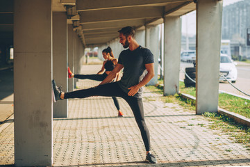 Young sports couple exercising in the urban environment