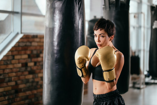 woman with athletic complection is striking blow. fight off. eager for fight. stuck at enemy