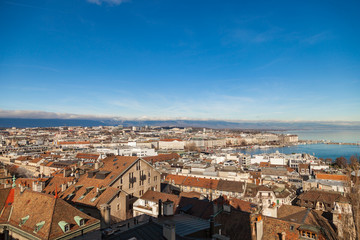 Fototapeta na wymiar Geneva old city roofs and lake. Geneva aerial view from St. Pierre Cathedral bell tower. Winter day in Geneva, Switzerland.