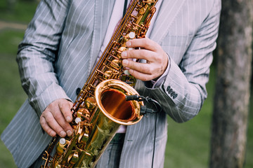 Fototapeta premium musician suit performs melody saxophone outside summer