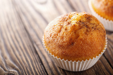 Classic muffins on a wooden old background in a white wrapper.