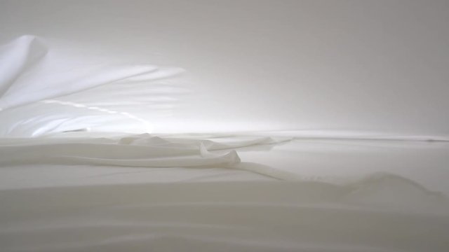 A background texture of soft white fabric textile material wave moving.