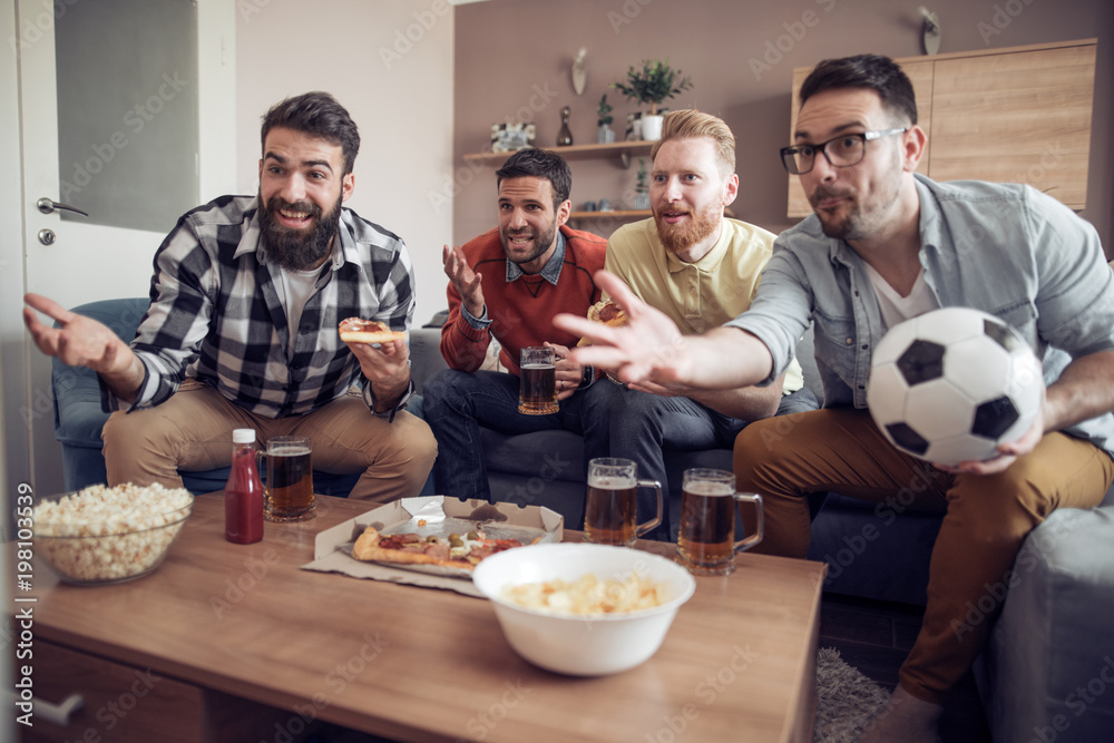 Wall mural Friends watching a football match on TV