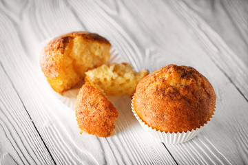 Classic muffins on a wooden old white background in a white wrapper.