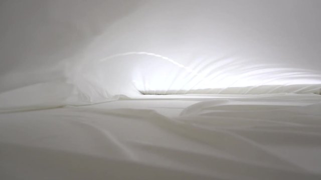 A background texture of soft white fabric textile material wave moving.