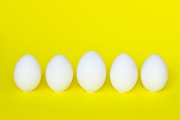 Food Ingredients,Breakfast,Easter Concept. White Chicken Eggs On Yellow Background.Minimal Art Design. Eggs Over Yellow Background. Abstract Background.
