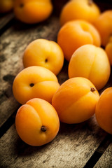 Apricots fresh arrangement close up in old wooden box on bright light in studio