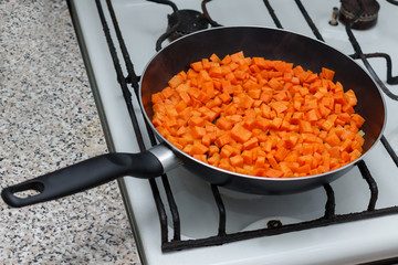 Fresh vegetables in a frying pan. Fresh vegetable products, freshly frozen odietic vegetables carrots are cooked in a frying pan on a gas stove.
