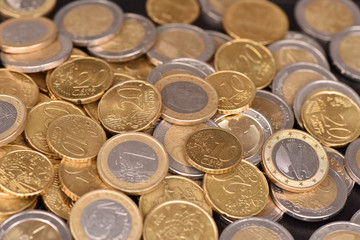Euro coins on a black background. Texture of money.