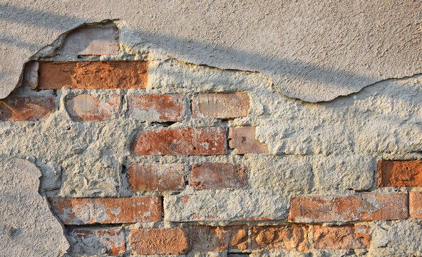 Fototapeta Zniszczona ściana budynku - widoczne cegły