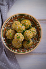 Bowl of meatballs with rice and vegetables on white wooden table