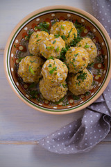 Bowl of meatballs with rice and vegetables on white wooden table