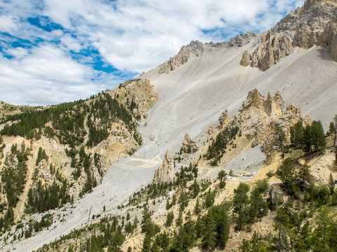 Road climbing to Col d'Izoard through Casse Desert sandy rocks, France
