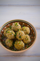 Bowl of meatballs with rice and vegetables on white wooden table