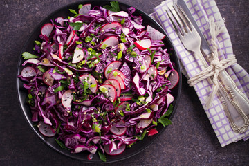 Plate of red cabbage, radish, chives, parsley and sesame seeds salad. Vegetarian or vegan healthy food concept