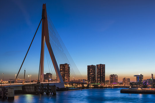 Travel Concepts, Ideas and Destinations. Amazing Cool View of Rotterdam Skyline with  Erasmus Bridge on Foregorund During Blue Hour.