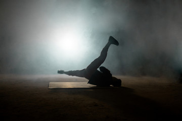 Handsome male dancer spinning on the back. performing backspin on the floor.kind of break dance