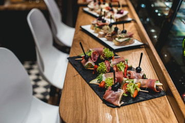 tasty pinchos with tuna, chorizos, salmon, egg, dried tomatoes, avocado, salmon, bacon, Hamon, Brie Cheese, Olives and Pesto Sauce, traditional spanish snack