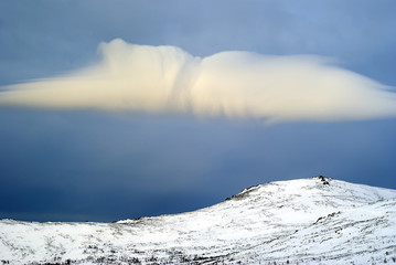 cloud above a snowy mountain peak; morning landscape in the vicinity of the mount Konzhakovskiy Kamen