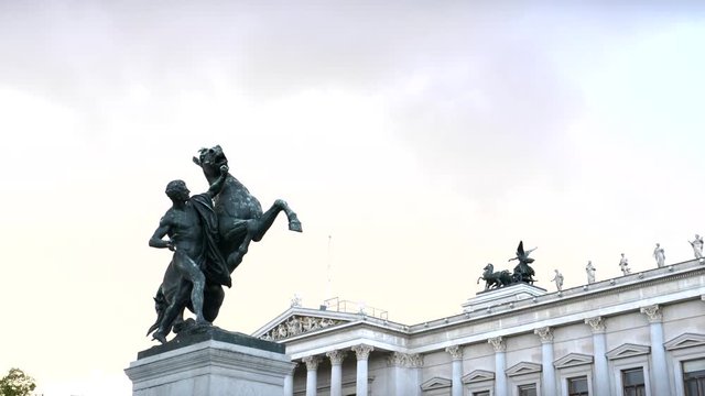 a zoom in shot of the horse tamer statue outside the parliament building in vienna, austria