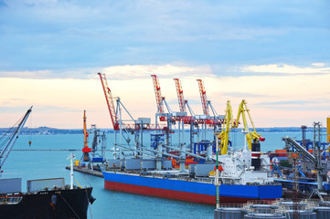 Naklejka premium Ship under crane at sunset