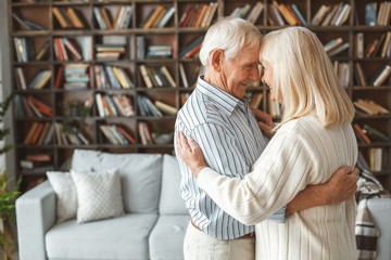 Senior couple at home retirement concept dancing ballroom dance heads together