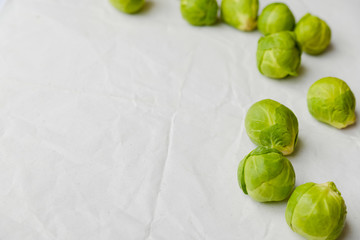Brussels sprouts green vegetables on light table background. Flat lay close up top view copyspace design. Health food lifestyle