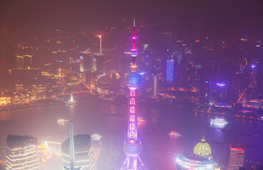 Beautiful super wide-angle night aerial view of Shanghai, China with Pudong district, TV tower, the Bund and scenery beyond the city, seen from the observation deck of Shanghai World Financial Center