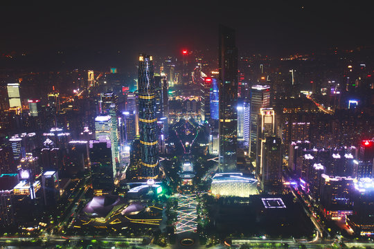 Beautiful wide-angle night aerial view of Guangzhou Zhujiang New Town financial district, Guangdong, China with skyline and scenery beyond the city, seen from the observation deck of Canton Tower
