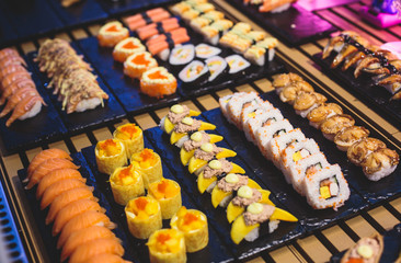 Decorated catering banquet table with different sushi rolls and nigiri sushi plate assortment on a party