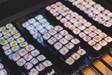 Decorated catering banquet table with different sushi rolls and nigiri sushi plate assortment on a party