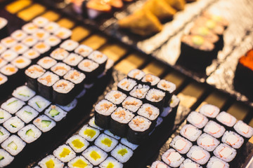 Decorated catering banquet table with different sushi rolls and nigiri sushi plate assortment on a party