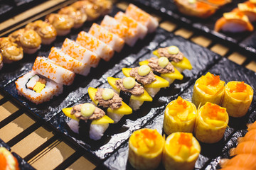 Decorated catering banquet table with different sushi rolls and nigiri sushi plate assortment on a party