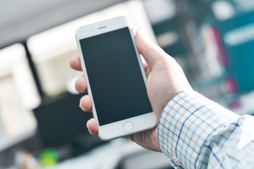 Hand hold mobile phone, person using smartphone. Top view closeup on black screen digital device mock up. Marketing technology design surface background, communication lifestyle