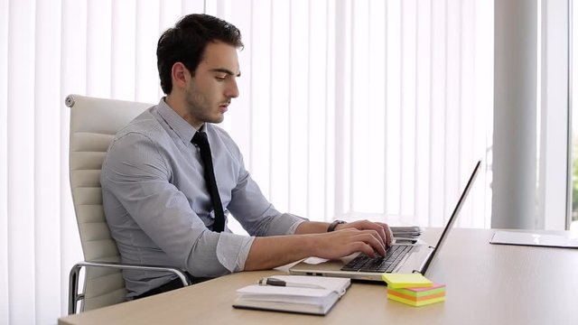 Young Businessman Typing On Laptop