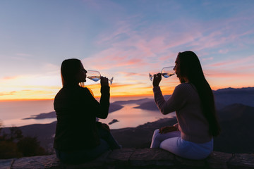 girls tasting wine at sunset