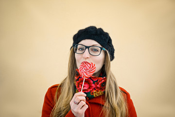 young girl in red eating candy in the shape of a heart