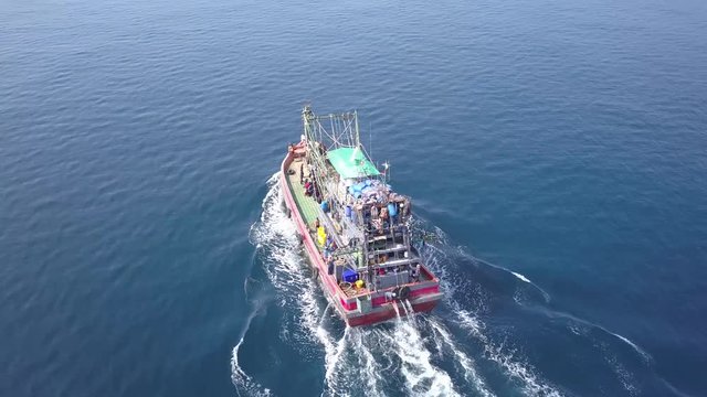 4k aerial drone view following a large fishing boat on the open ocean in the Mergui Archipelago in Myanmar (Burma)