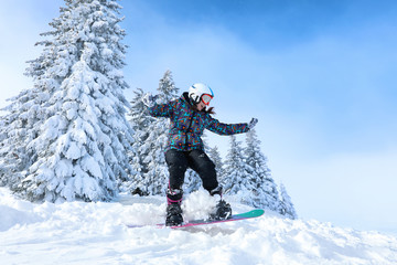 Fototapeta na wymiar Female snowboarder on ski piste at snowy resort. Winter vacation