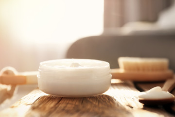 Jar with body care cream on wooden table