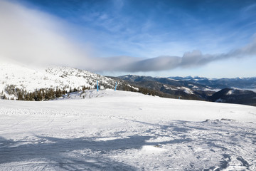 Fototapeta na wymiar Ski slope at snowy resort on winter day
