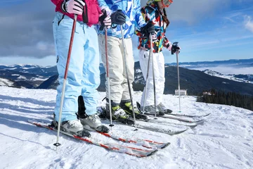 Fotobehang Friends on ski piste at snowy resort. Winter vacation © Africa Studio