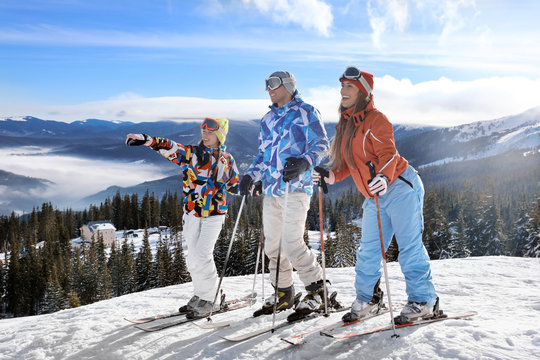 Friends on ski piste at snowy resort. Winter vacation