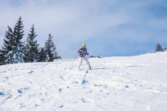 Woman skiing downhill at snowy resort. Winter vacation